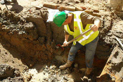 847252 Afbeelding van een archeoloog van de gemeente Utrecht die aan het graven is op de binnenplaats van het ...